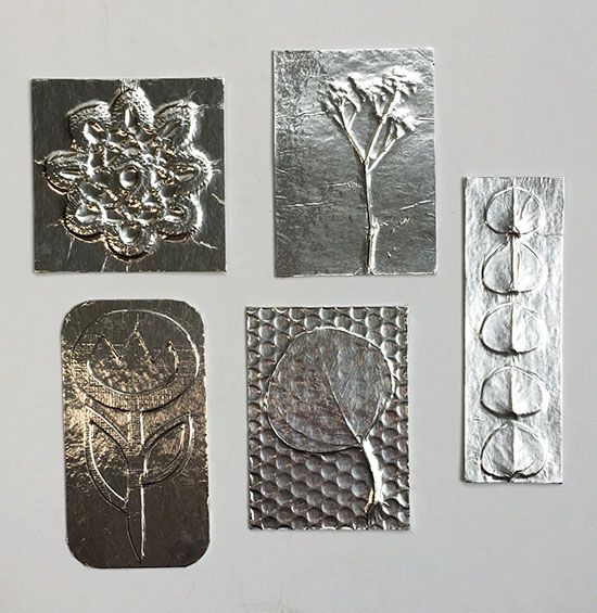 four different types of metal stamping on a white surface with flowers and circles around them