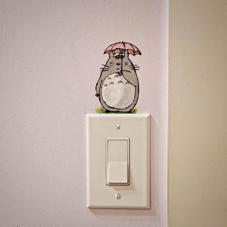 a push light switch with a cartoon character on it's cover and an umbrella over its head