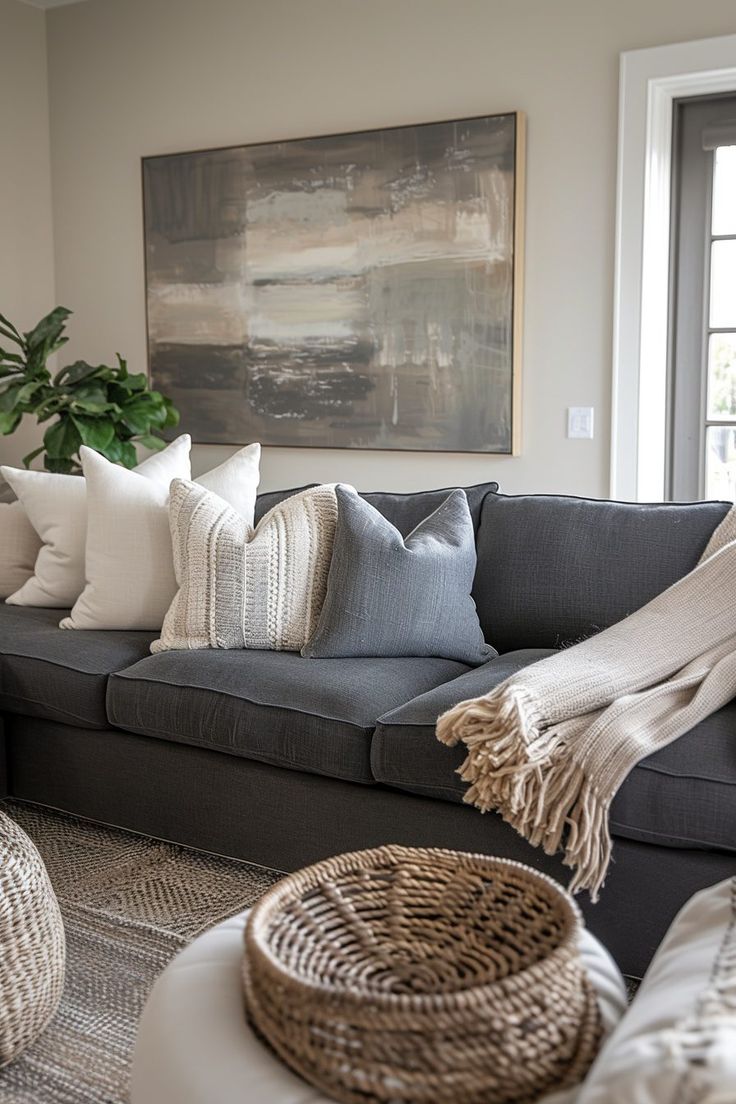 a living room filled with lots of pillows and blankets on top of a couch next to a potted plant