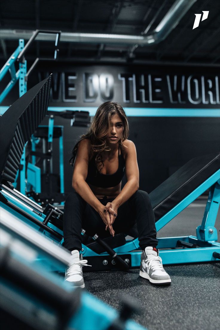 a woman squatting down in the gym