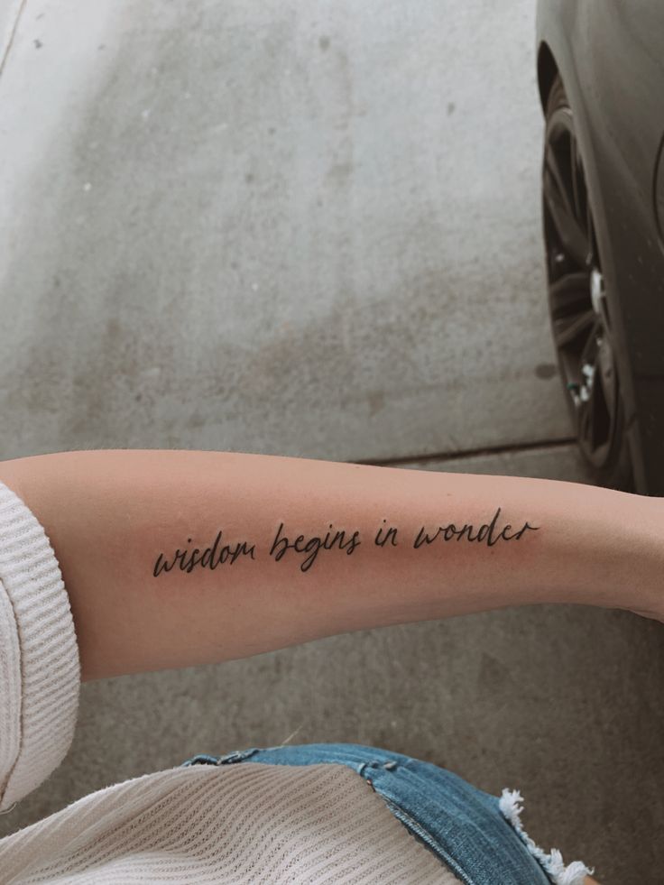 a person with a tattoo on their arm that says,'random begins in wonder '