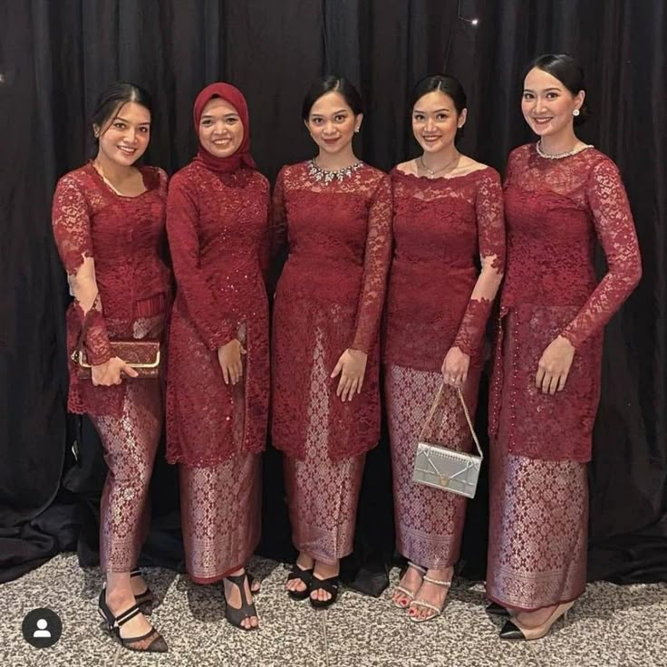 four women in red dresses standing next to each other