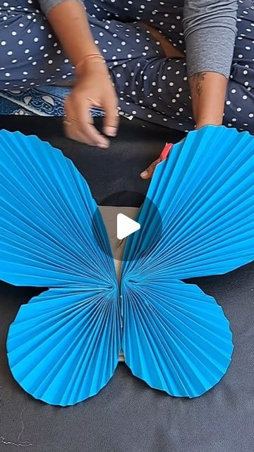 a person is making a butterfly out of paper