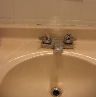 a bathroom sink with two faucets on the side and no one in it