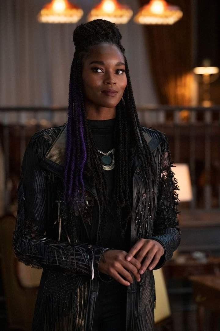 a woman with purple dreadlocks standing in a room