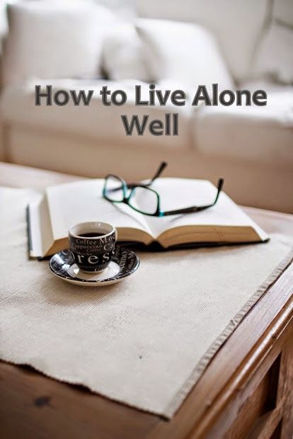 an open book sitting on top of a wooden table next to a cup of coffee