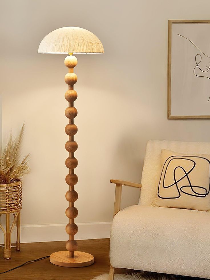 a living room with a chair, lamp and pictures on the wall