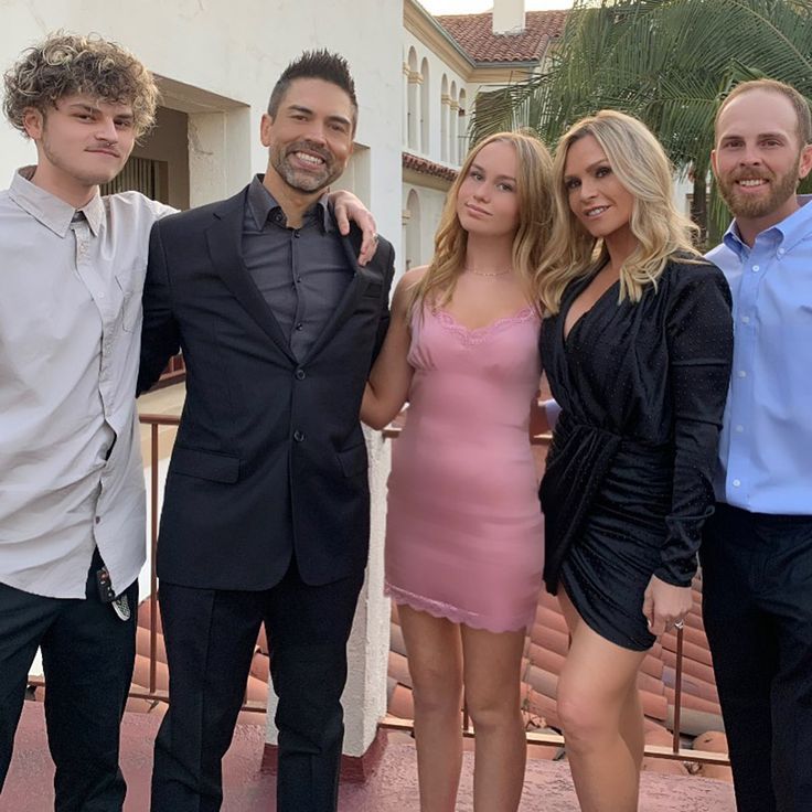 three men and two women posing for the camera