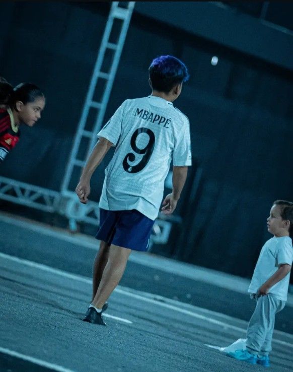 two boys and a girl are playing soccer