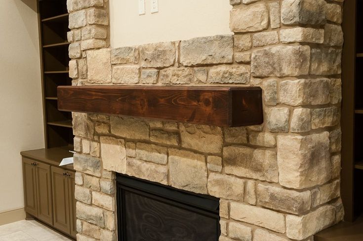 a stone fireplace with a shelf above it