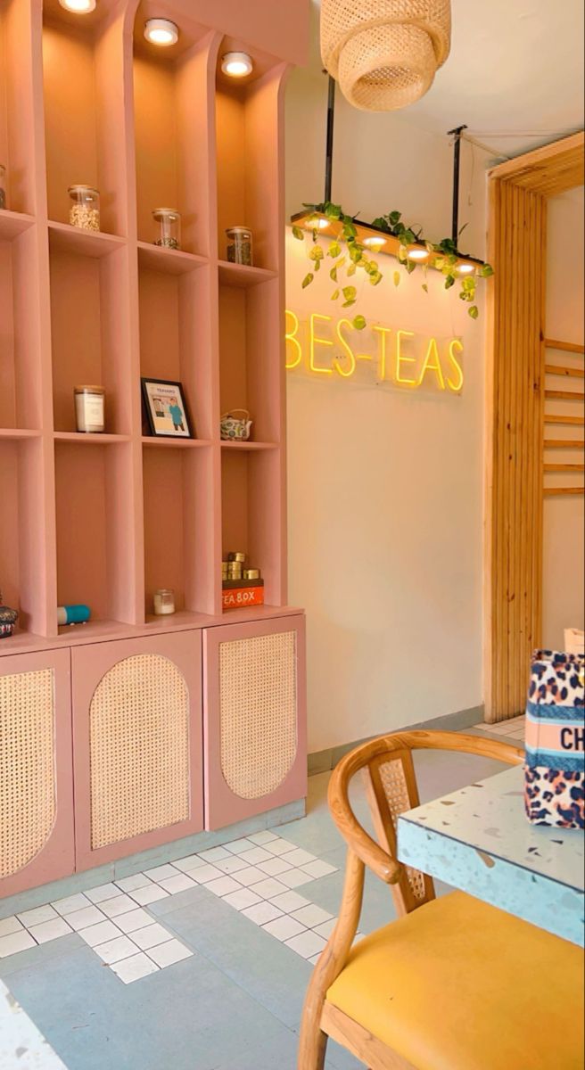 the interior of a restaurant with pink shelves and wicker chairs