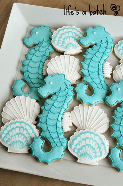 decorated cookies in the shape of seahorses on a plate