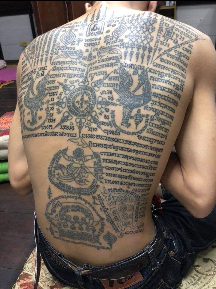 the back of a man with tattoos on his body