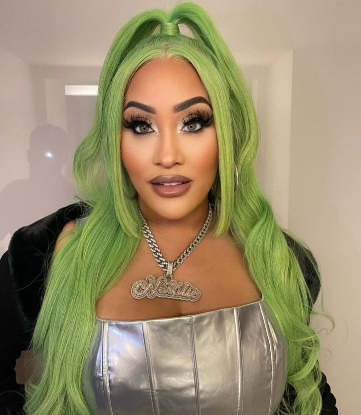 a woman with green hair wearing a silver dress