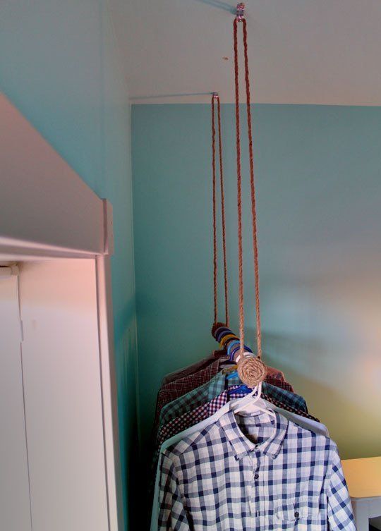 a shirt hanging from a rope in a room with blue walls and white furniture,