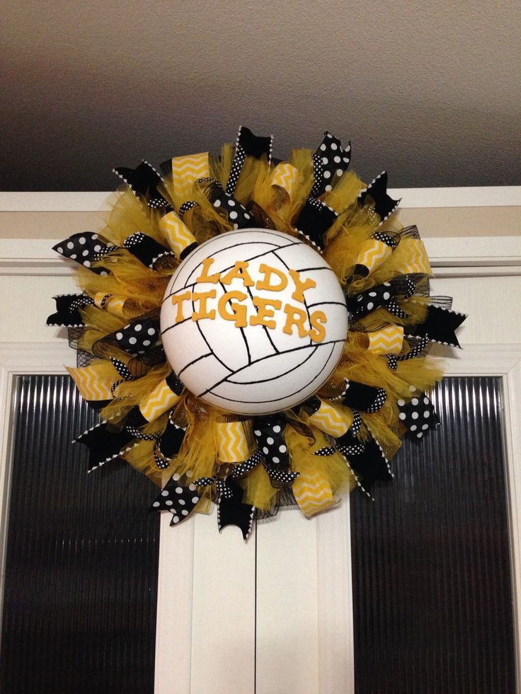 a basketball wreath on the front door of a house with black and yellow ribbon around it