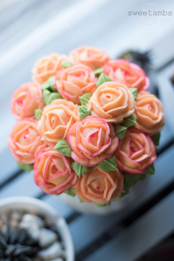 a bouquet of pink roses sitting on top of a table next to a potted plant