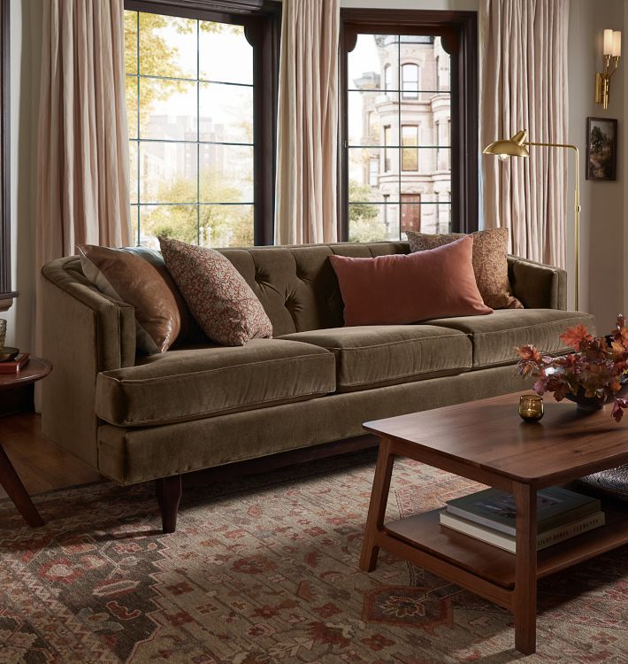 a living room filled with furniture and lots of window sill space next to a coffee table