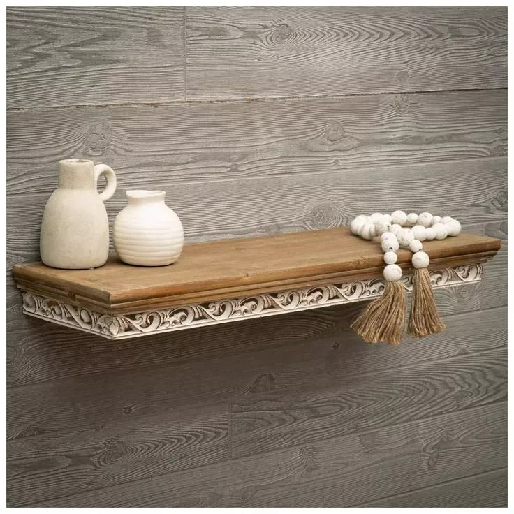 two white vases sitting on top of a wooden shelf