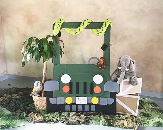 an elephant is sitting on the bed next to a green truck with trees in it