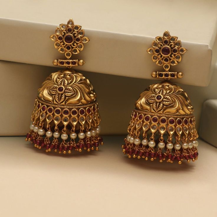 Description These antique jhumki earrings by Tarinika is a timeless design and sure will be your next favorite earrings. Crafted beautifully in nakshi pattern to give a luxurious look to your style. The antique gold color and colorful CZ stones and beads adds unique contrast to the design. Style them alone or match with other Tarinika antique jewelry. Details & Specifications: Materials used: Brass Alloy with Antique Plating Weight – 64 gm Length – 6.5 cm Make it custom Want to make it a custom Latest Gold Earrings Designs Modern, Jhumki Earrings Gold, Traditional Gold Jewellery, Chocolate Doll, Women Gold Earrings, Golden Jhumka, Gold Earrings Design, Beautiful Gold Earrings, Maharashtrian Jewellery