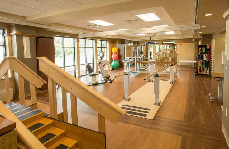 an empty gym with exercise equipment on the floor