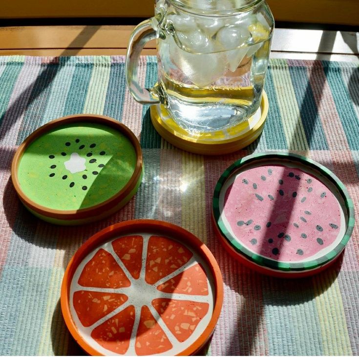 there are four bowls with slices of watermelon in them and a pitcher on the table