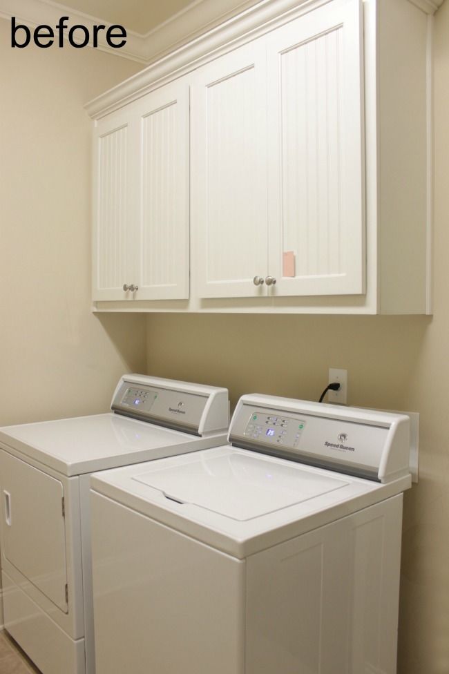 a washer and dryer sitting in a room next to each other on top of cabinets