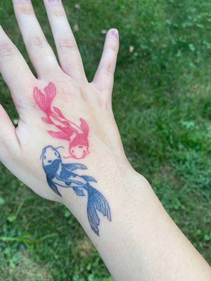 a person's hand with a fish tattoo on it