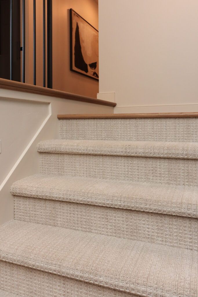 a set of stairs with carpeted steps leading up to the second floor in a home