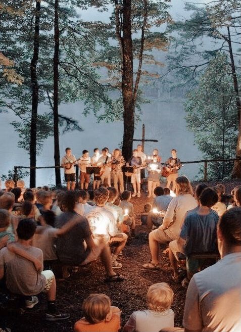 a group of people sitting in the woods at night