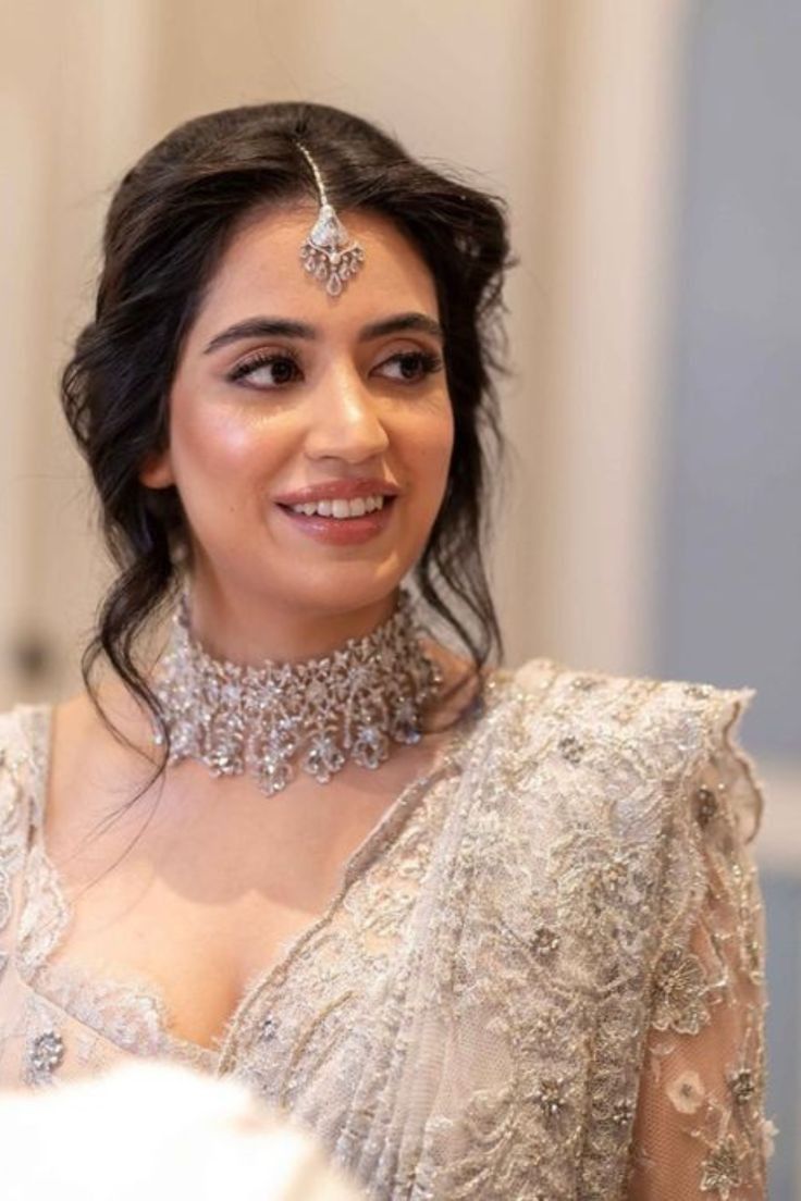 a woman in a white dress wearing a necklace and choker with jewels on it