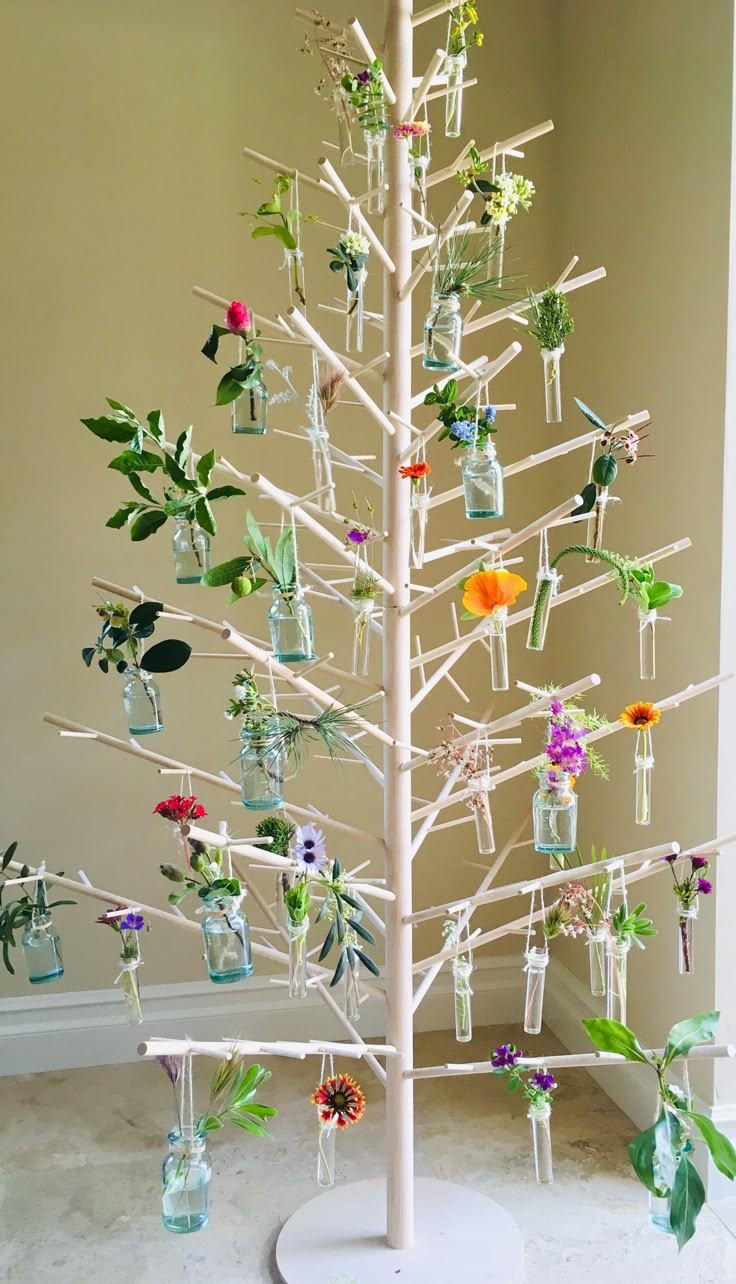 a white tree decorated with flowers and bottles