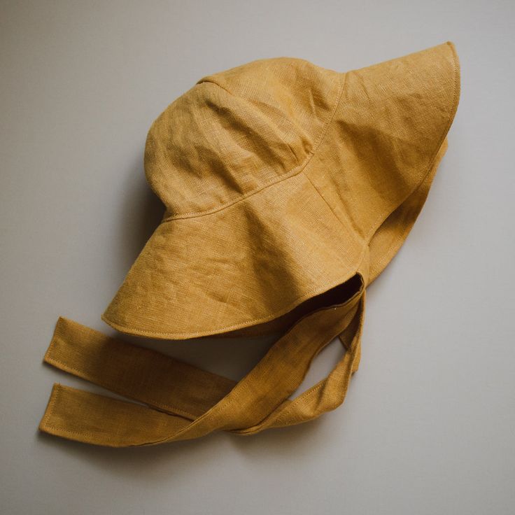 a yellow hat laying on top of a white table