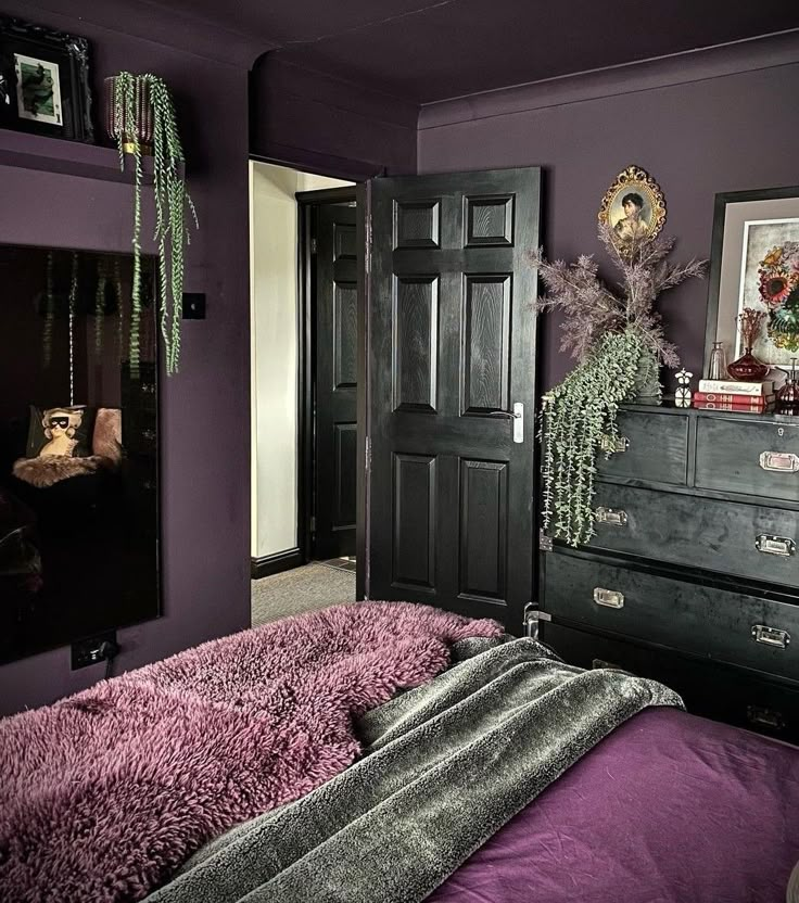 a bedroom with purple walls and black furniture