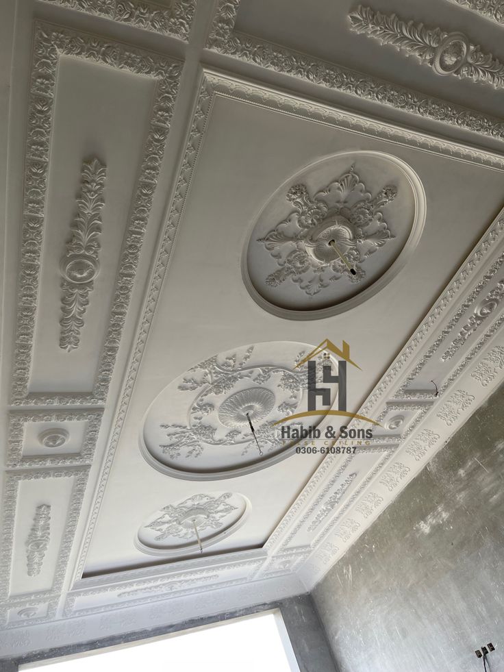 the ceiling is painted white and has ornate designs on it, along with other decorative items