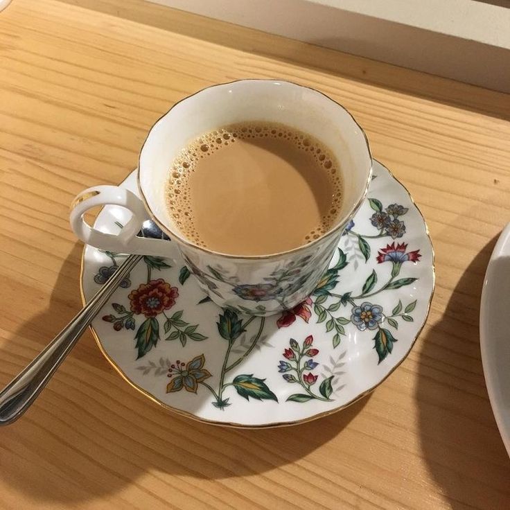 a cup of coffee sitting on top of a saucer next to a plate with a spoon