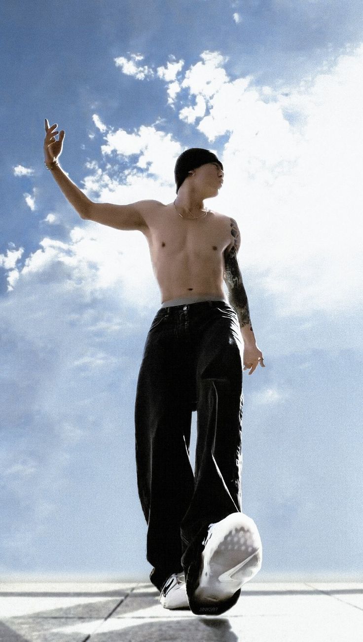 a man with no shirt on riding a skateboard in the air and holding his hand up