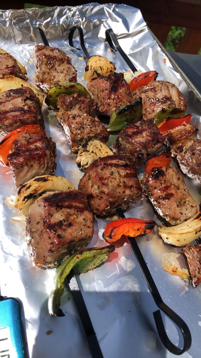 several skewered meats and vegetables on a sheet of aluminum foil