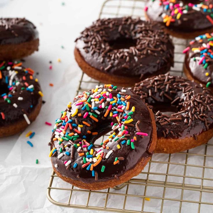 chocolate frosted donuts with sprinkles on a cooling rack