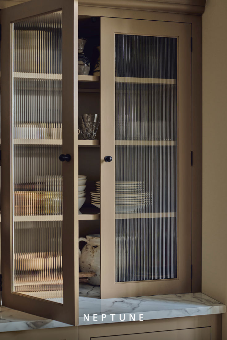 a cabinet with glass doors is shown in the kitchen