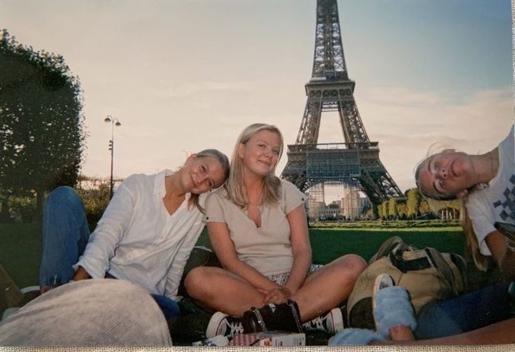 three people sitting in front of the eiffel tower