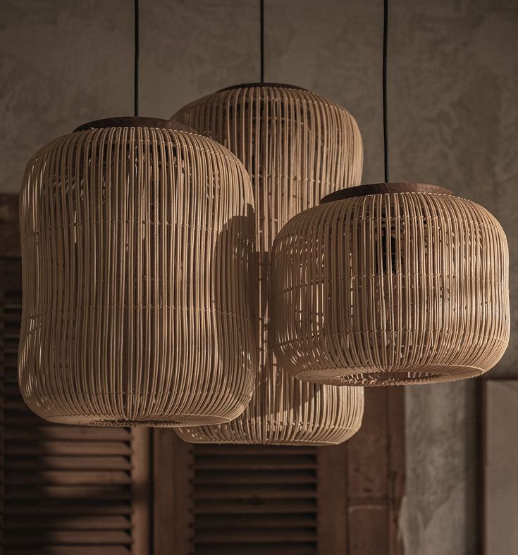 three light fixtures hanging from the ceiling in a room with wooden shutters and windows