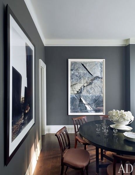 a dinning room table with chairs and pictures on the wall in front of it