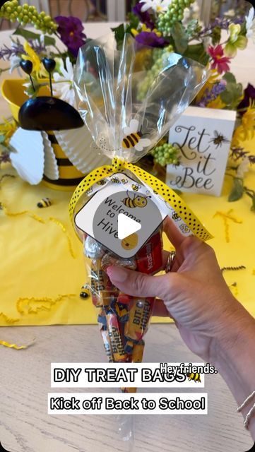 a person holding a bottle of honey in front of a table with flowers and decorations