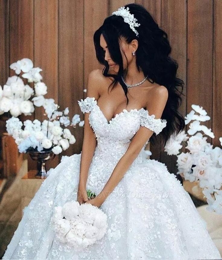 a woman in a white wedding dress standing next to flowers