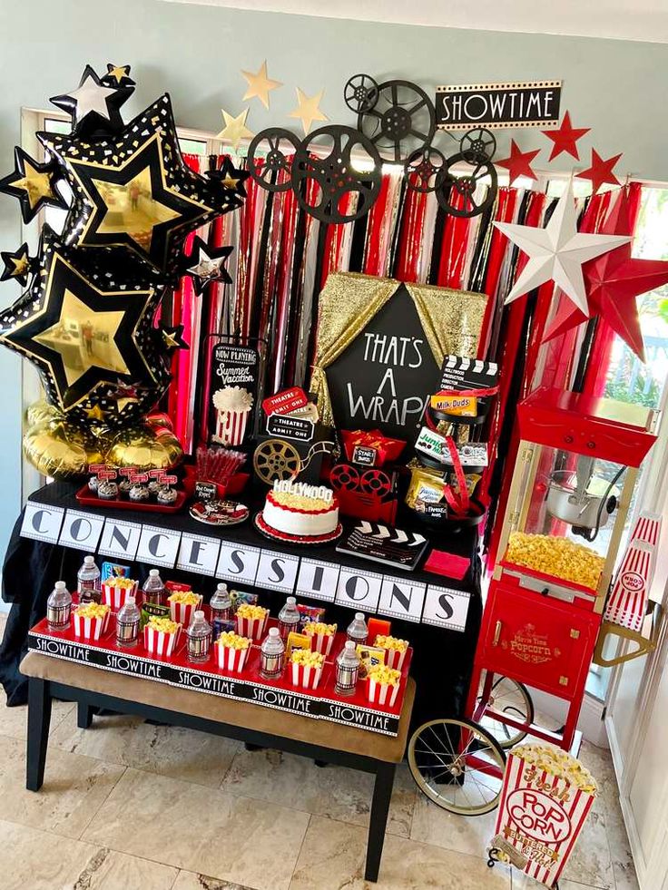 a table topped with lots of red and gold items next to a wall covered in stars