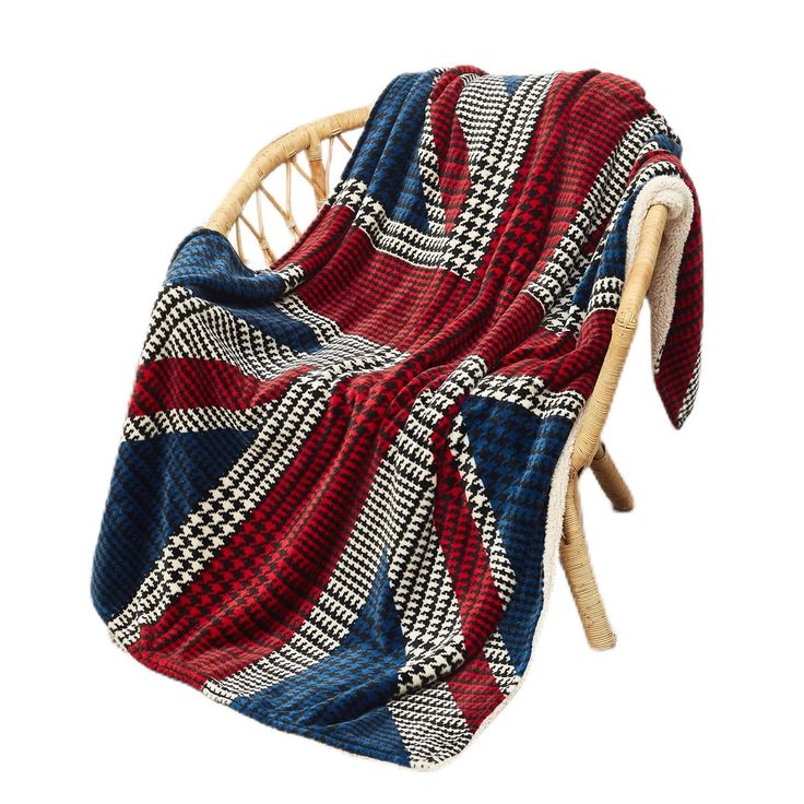 a red, white and blue blanket sitting on top of a wicker rocking chair