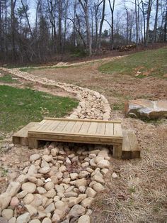 a wooden bench sitting on top of a pile of rocks