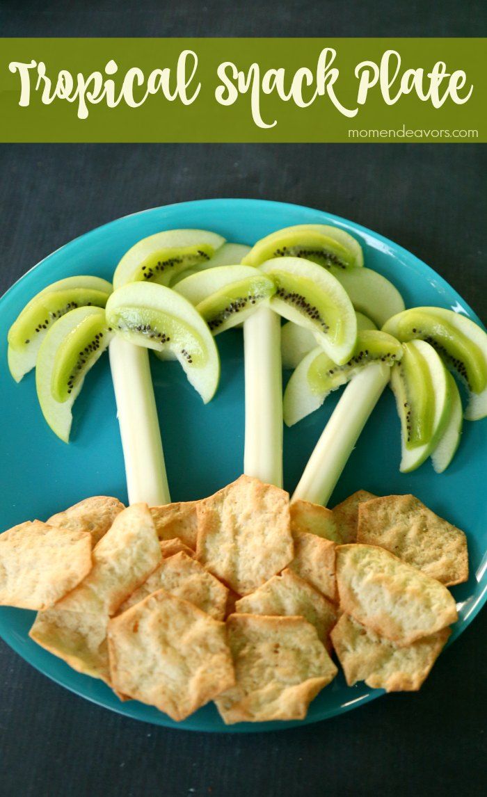 a blue plate topped with crackers and kiwis on top of each other